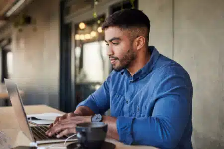 a man sitting at a table using a laptop